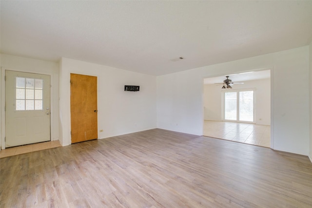 unfurnished room with light hardwood / wood-style floors, ceiling fan, and a healthy amount of sunlight