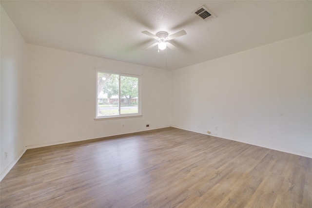 spare room featuring ceiling fan, light hardwood / wood-style floors, and a textured ceiling