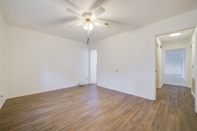 spare room with ceiling fan, wood-type flooring, and a textured ceiling