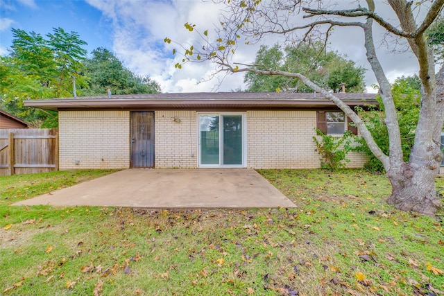 rear view of house featuring a lawn and a patio area