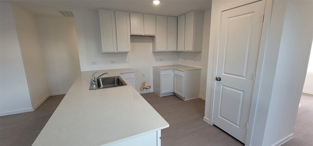 kitchen featuring white cabinetry, sink, and light hardwood / wood-style flooring