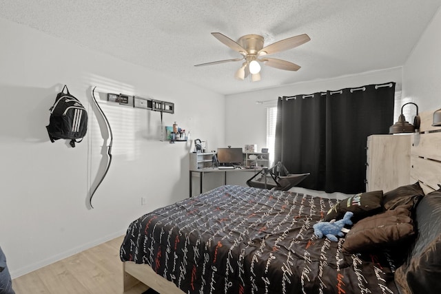 bedroom with a textured ceiling, light hardwood / wood-style flooring, and ceiling fan