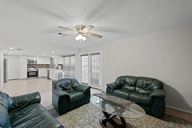 tiled living room featuring a textured ceiling and ceiling fan