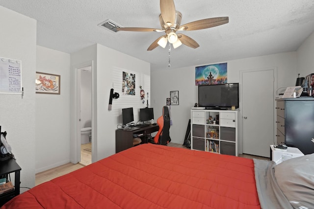 bedroom with ceiling fan, light wood-type flooring, and a textured ceiling