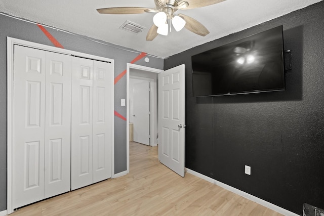 bedroom featuring light wood-type flooring, a closet, and ceiling fan