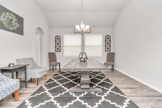 interior space featuring hardwood / wood-style flooring, lofted ceiling, and an inviting chandelier