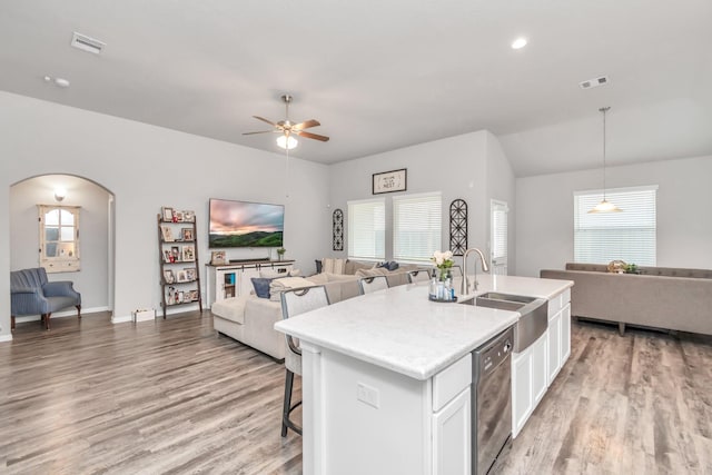 kitchen with dishwasher, sink, hardwood / wood-style flooring, a wealth of natural light, and white cabinetry