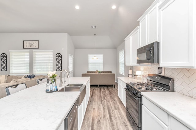 kitchen featuring white cabinets, backsplash, light hardwood / wood-style flooring, and black appliances