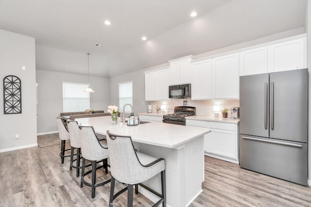 kitchen featuring sink, black appliances, light hardwood / wood-style flooring, white cabinets, and an island with sink