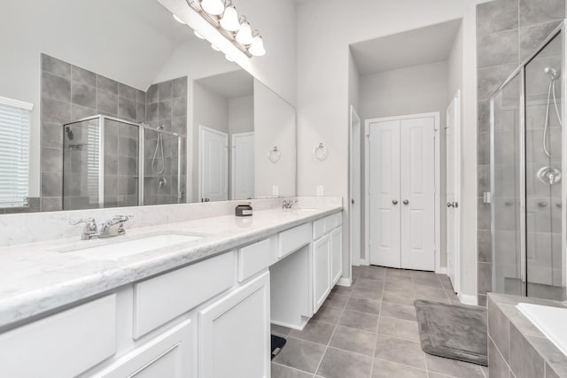 bathroom with tile patterned floors, vanity, shower with separate bathtub, and vaulted ceiling