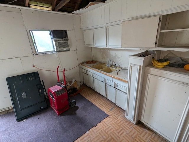 kitchen with white cabinets, light parquet flooring, cooling unit, and sink