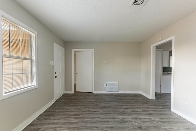 spare room featuring dark hardwood / wood-style flooring, plenty of natural light, and a textured ceiling