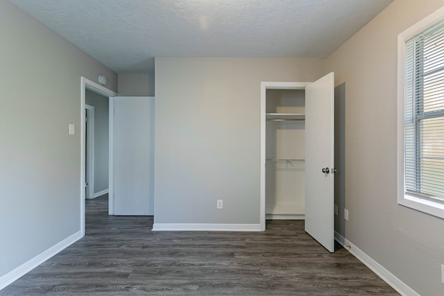 unfurnished bedroom featuring a textured ceiling and dark wood-type flooring