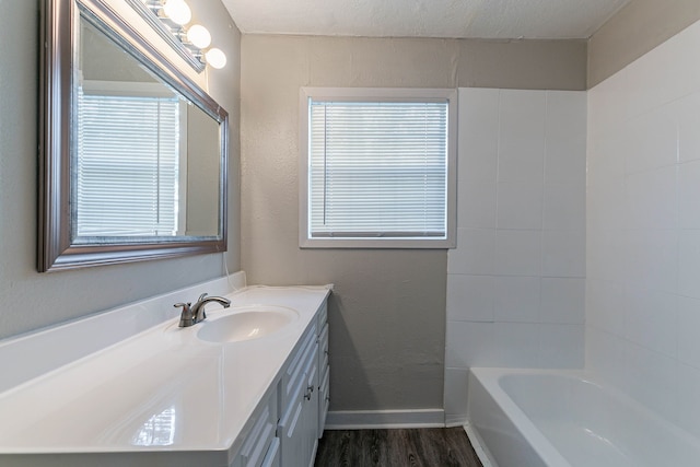 bathroom featuring hardwood / wood-style floors, vanity, shower / bathtub combination, and a textured ceiling