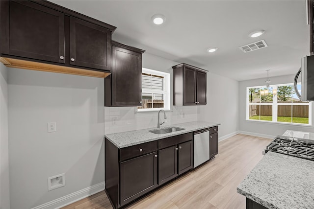 10318 Prairie Dunes Ln, Cleveland, TX 77327 - kitchen featuring dishwasher, a sink, baseboards, dark brown cabinetry, and backsplash