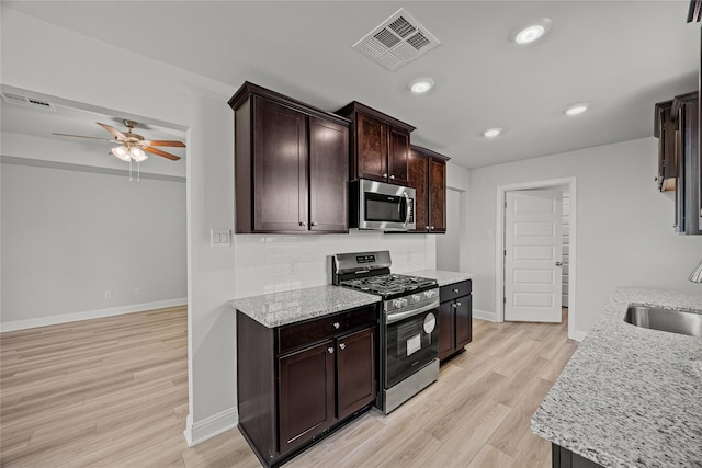10318 Prairie Dunes Ln, Cleveland, TX 77327 - kitchen featuring appliances with stainless steel finishes, a sink, ceiling fan, baseboards, and tasteful backsplash