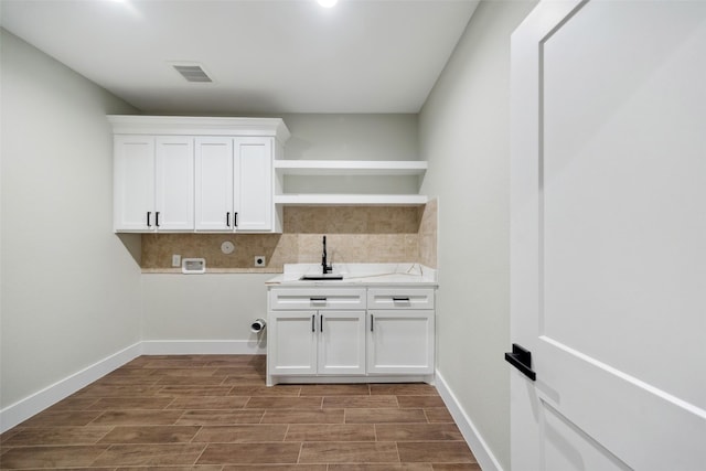 laundry room with electric dryer hookup, cabinets, sink, washer hookup, and hardwood / wood-style flooring