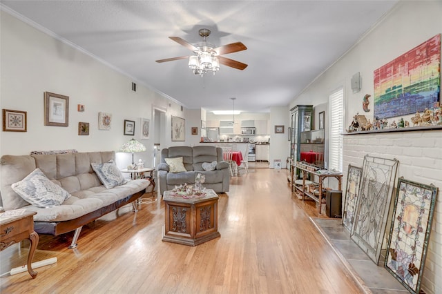 living room with ceiling fan, light wood-type flooring, and crown molding