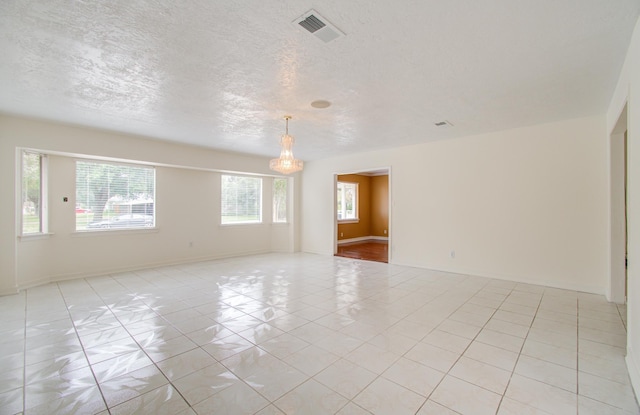 tiled spare room featuring a textured ceiling