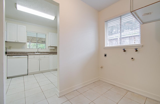 washroom with sink, washer hookup, hookup for an electric dryer, crown molding, and light tile patterned flooring