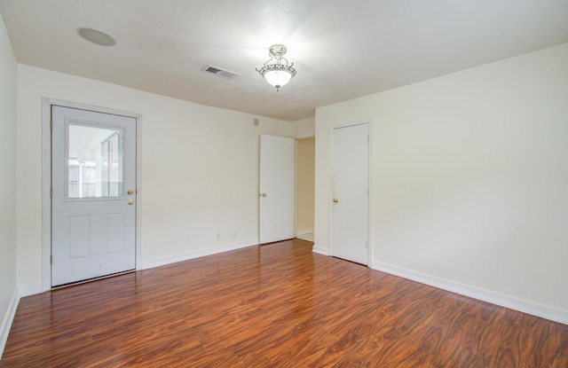 empty room featuring dark wood-type flooring and a textured ceiling