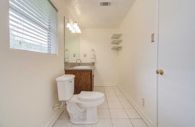 bathroom with toilet, vanity, and tile patterned floors