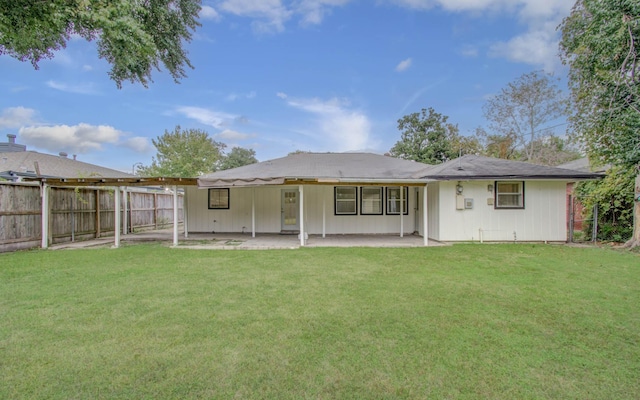 rear view of house featuring a yard and a patio