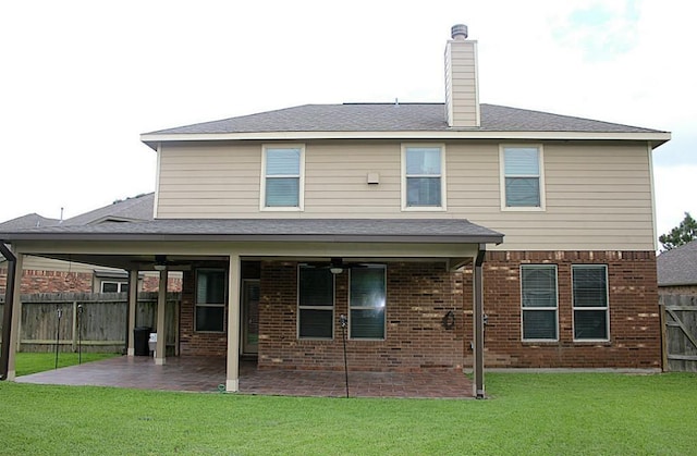 rear view of house with a patio, ceiling fan, and a lawn