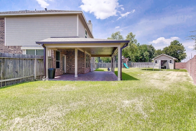 view of yard with a playground, a patio, and a storage unit