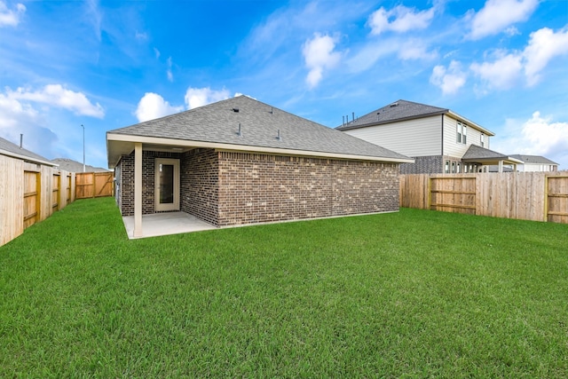 back of property with a lawn and a patio