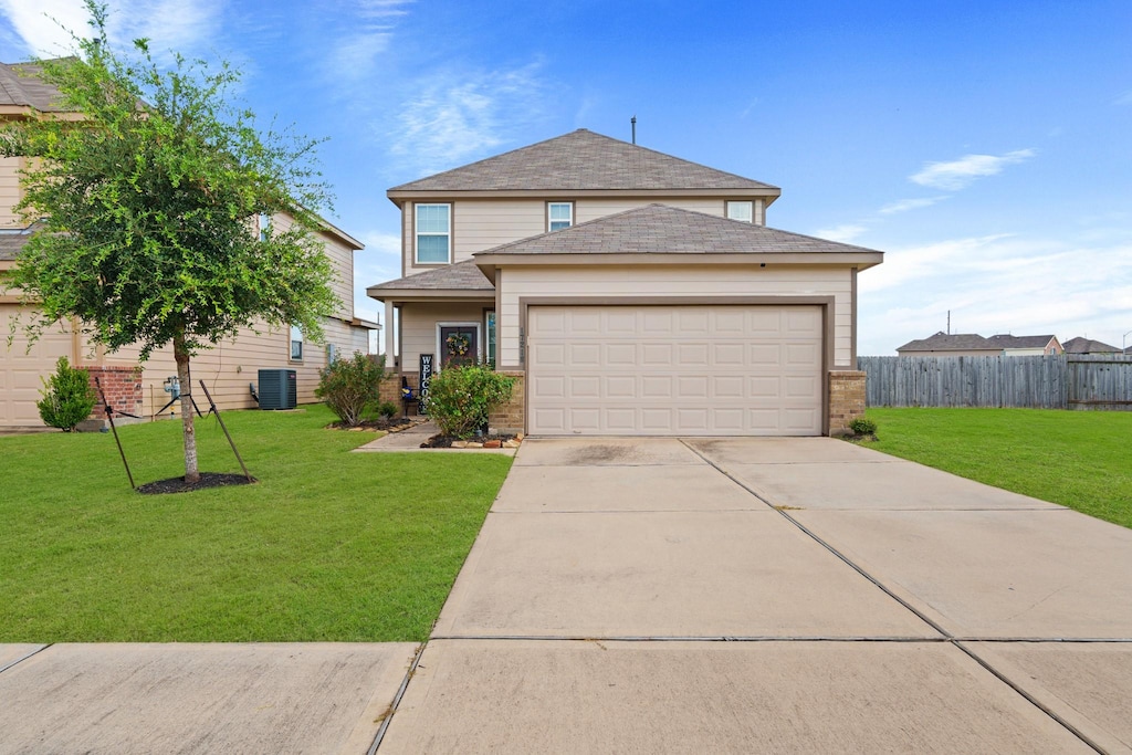 view of front of property with central AC, a front lawn, and a garage