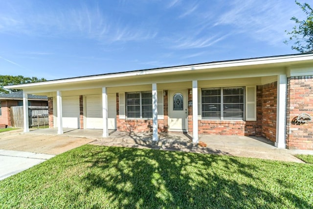 view of front of property featuring covered porch, a garage, and a front lawn