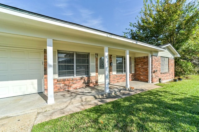 exterior space with a yard, covered porch, and a garage