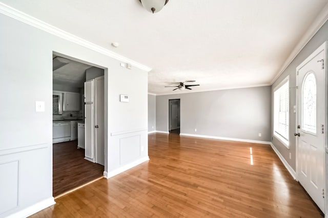 unfurnished living room featuring ceiling fan, ornamental molding, and hardwood / wood-style flooring