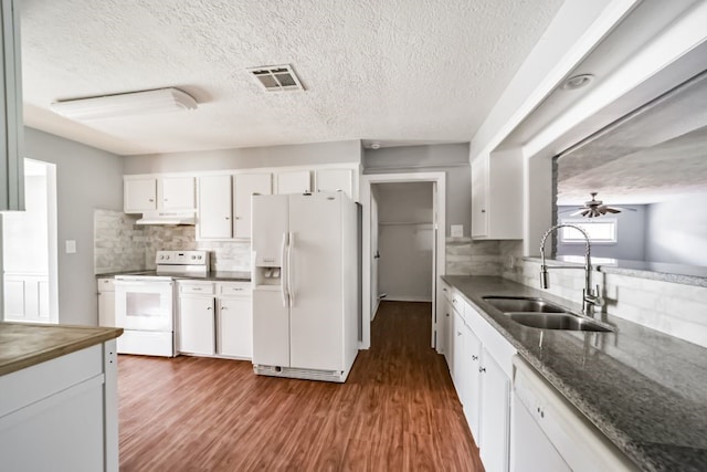 kitchen featuring tasteful backsplash, white appliances, dark wood-type flooring, sink, and white cabinets