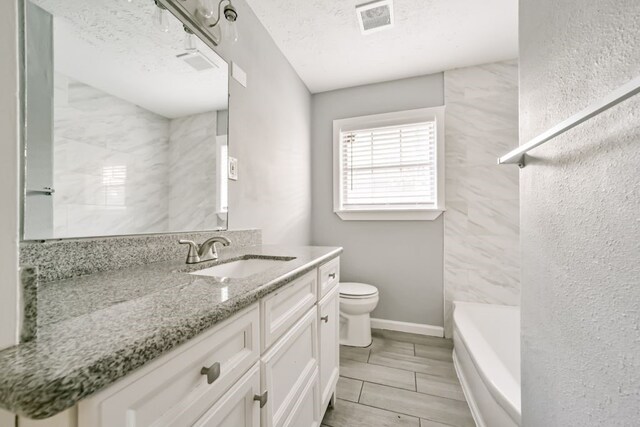 full bathroom featuring vanity, tiled shower / bath combo, a textured ceiling, and toilet