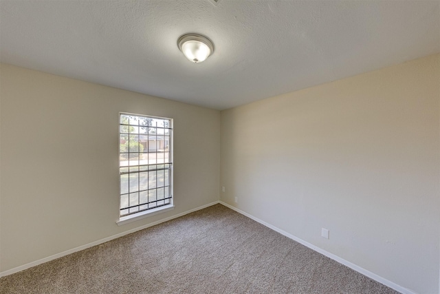 carpeted spare room featuring a textured ceiling