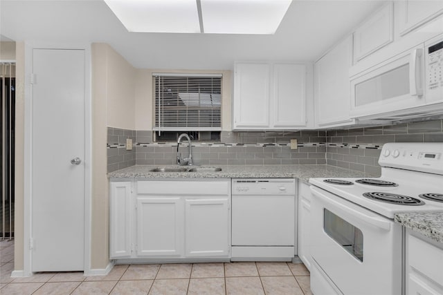 kitchen with backsplash, white appliances, sink, light tile patterned floors, and white cabinets