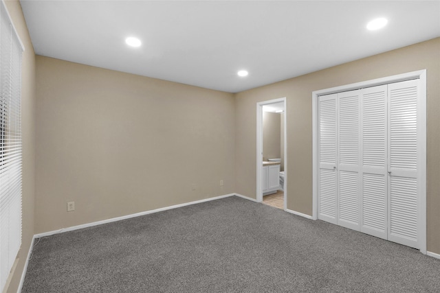 unfurnished bedroom with light carpet, ensuite bathroom, and a closet