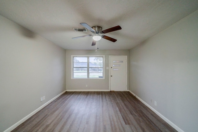 spare room with ceiling fan and dark hardwood / wood-style flooring