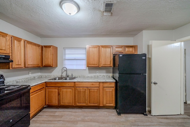 kitchen featuring sink, ventilation hood, light hardwood / wood-style floors, a textured ceiling, and black appliances