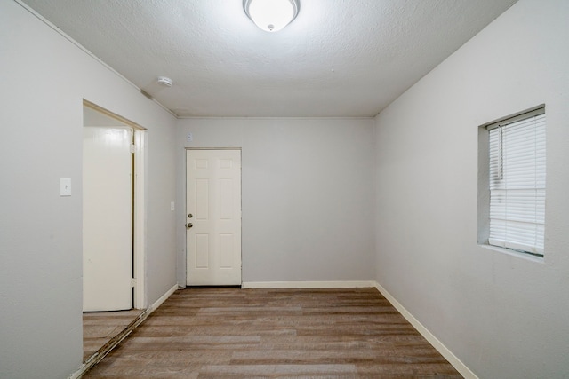 empty room with light hardwood / wood-style flooring and a textured ceiling