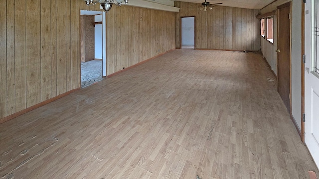 unfurnished room featuring wood walls, ceiling fan, and light hardwood / wood-style floors