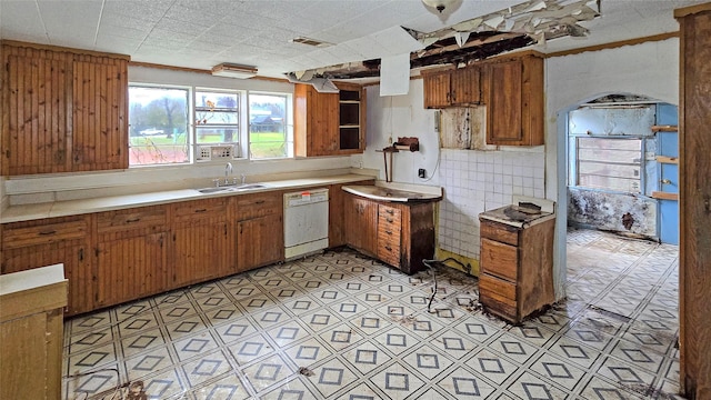 kitchen featuring tasteful backsplash, sink, and white dishwasher