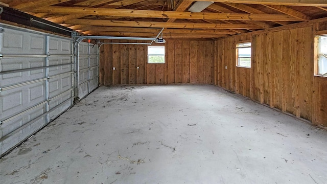 garage with wooden walls and a garage door opener