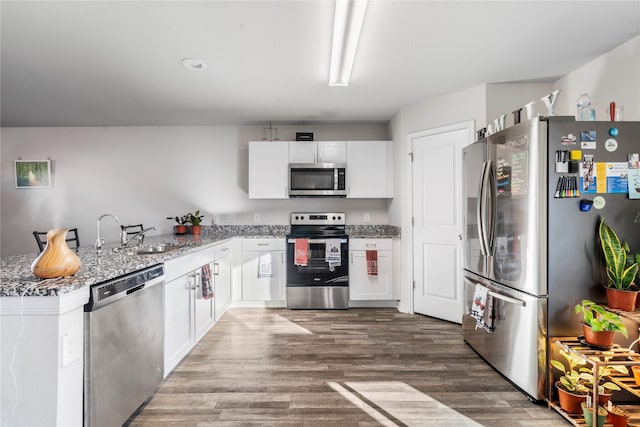 kitchen featuring sink, kitchen peninsula, dark hardwood / wood-style flooring, white cabinetry, and stainless steel appliances