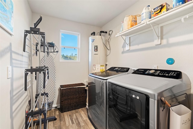 clothes washing area featuring separate washer and dryer, water heater, and hardwood / wood-style flooring