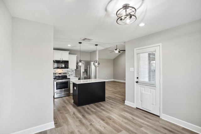 kitchen with white cabinetry, a center island, stainless steel appliances, and light hardwood / wood-style flooring