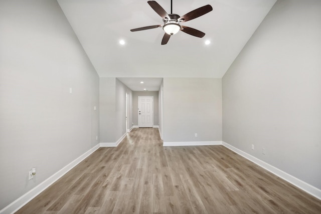 unfurnished living room with ceiling fan, light wood-type flooring, and vaulted ceiling