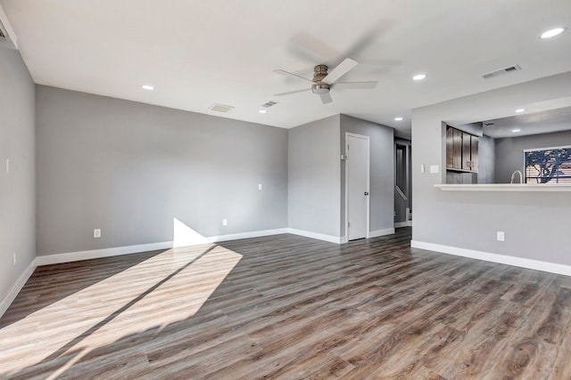 unfurnished living room featuring ceiling fan and dark wood-type flooring